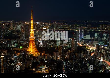 Rues de la région de Tokyo de nuit, vu depuis le haut de l'un des plus hauts bâtiments de Roppongi Hills, avec la Tour de Tokyo illuminée rougeoyant. Banque D'Images