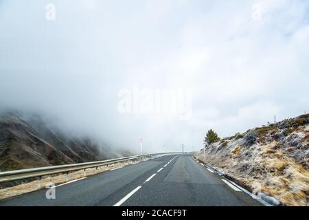 Route couverte de brouillard entourée de collines Banque D'Images