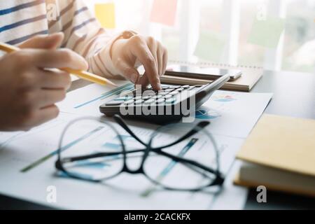 Femme d'affaires travaillant dans les finances et la comptabilité analyse du budget financier avec calculatrice au bureau Banque D'Images