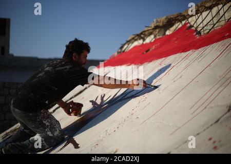 Idlib, Syrie. 05 août 2020. Un syrien a vu peindre un drapeau libanais sur les murs de la ville de Bennach, à l'est d'Idlib, le 6 août 2020, pour la solidarité des Syriens avec le peuple libanais après l'exposition du port de Beyrouth à une énorme explosion hier, tuant plus de 100 et 4000 blessés. (Photo par Ali Haj Suleiman/INA photo Agency/Sipa USA) crédit: SIPA USA/Alay Live News Banque D'Images