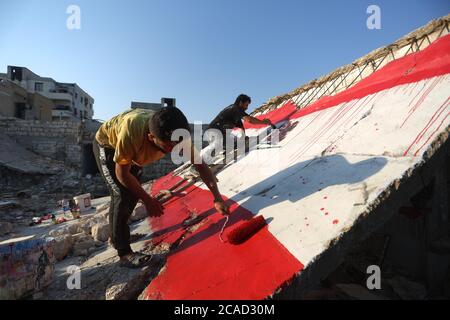 Idlib, Syrie. 05 août 2020. Un syrien a vu peindre un drapeau libanais sur les murs de la ville de Bennach, à l'est d'Idlib, le 6 août 2020, pour la solidarité des Syriens avec le peuple libanais après l'exposition du port de Beyrouth à une énorme explosion hier, tuant plus de 100 et 4000 blessés. (Photo par Ali Haj Suleiman/INA photo Agency/Sipa USA) crédit: SIPA USA/Alay Live News Banque D'Images