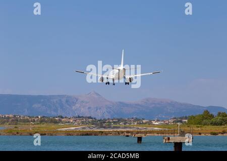 L'avion du passager atterrit à l'aéroport de Kerkyra. Grèce, île de Corfou. Diminution de la hauteur, gros plan. Piste sur fond de montagnes et de mer. Banque D'Images