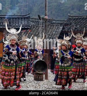 Jeunes filles qui exécutent une danse traditionnelle. Ils sont du long jupe Miao peuple. Région de Kaili, province de Guizhou, Chine Banque D'Images