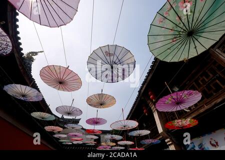 De nombreux parasols en papier huilé suspendus dans la vieille ville chinoise. Grand angle. Artisanat chinois populaire Banque D'Images