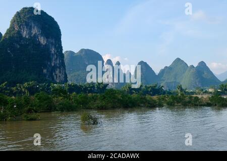 des montagnes verdoyantes et des arbres sur les berges. Au Lijiang (rivière Li) à Yangshuo Guilin, ville de Guangxi en Chine. Forme karstique Banque D'Images
