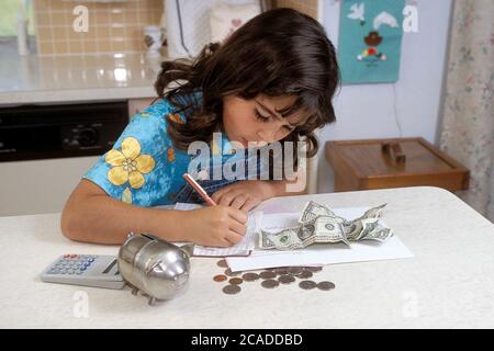 Austin Texas États-Unis, 1998 : huit ans, une jeune fille panaméenne-américaine prépare le dépôt pour le compte d'épargne à partir de dollars et de pièces qu'elle a économisé.. MR ©Bob Daemmrich Banque D'Images