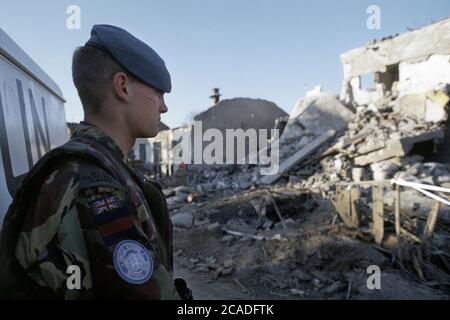 29 mars 1994 pendant la guerre en Bosnie : un soldat britannique du 1er Bataillon Coldstream Guards tient la garde à côté de son Land Rover, au milieu des ruines de Stari Vitez. Banque D'Images