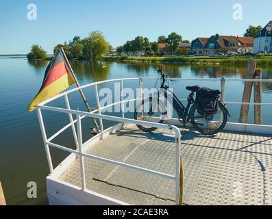 Steinhude, Allemagne, 29 mai 2020: Vélo électrique pendant le transport sur un bateau d'excursion avec drapeau national allemand au-dessus du Steinhuder Meer près de Hann Banque D'Images