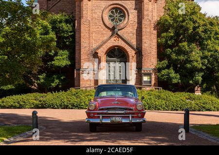 Les voitures d'époque sont souvent utilisées comme voitures de mariage. Un Plymouth historique est stationné devant l'église de Jyväskylä, dans le centre de la Finlande. Banque D'Images