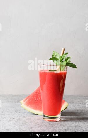 Un verre de cocktail de pastèque décorez la menthe sur fond gris. Gros plan. Verticale. Banque D'Images