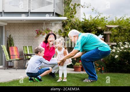 Couple heureux de vieux grands-parents s'amuser avec les petits-enfants Banque D'Images