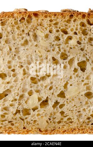 Tranche de pain d'épeautre, par le dessus, gros plan. Pain au levain brun, mélange de farine d'épeautre, levain, graines de tournesol et épices, cuit au four. Aliments de base. Banque D'Images