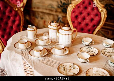 Gros plan sur une table en dentelle blanche avec chaises rouges en peluche. Banque D'Images