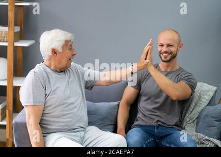 Joyeux grand-père qui donne le Grand cinq à son petit-fils Banque D'Images