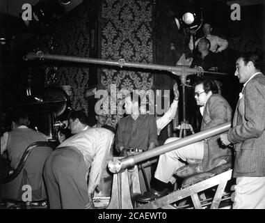 Le réalisateur adjoint FREDDIE FLECK (en lunettes à l'arrière au milieu) ORSON WELLES et le cinéaste STANLEY CORTEZ (à l'extrême droite) et l'équipe de tournage sur scène ont fait du bruit pendant le tournage DU MAGNIFIQUE film AMBERSONS 1942, le roman ORSON WELLES Booth Tarkington, scénario Orson Welles RKO radio Pictures Banque D'Images