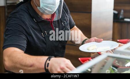 Service de restauration à l'hôtel ou au restaurant. Le chef prépare des plats au restaurant et les prépare dans des plats jetables Banque D'Images
