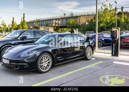 Une voiture électrique hybride Porsche Panamera 10 se recharge dans un centre de concessionnaires Porsche en Allemagne, en Europe Banque D'Images