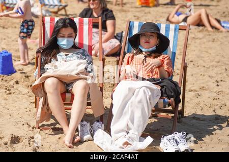 Scarborough, Royaume-Uni. 31 juillet 2020. Les baigneurs de soleil portant des masques de visage assis sur des chaises longues à South Bay Beach par temps chaud.le Royaume-Uni est prévu de se prélasser car les températures atteindront 36 degrés Celsius dans la capitale lors d'une mini vague de chaleur. Credit: Yiannis Alexopoulos/SOPA Images/ZUMA Wire/Alay Live News Banque D'Images