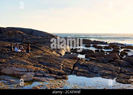 Personnes assises sur Coastal Rocks, Leeuwin, Augusta, Australie occidentale Banque D'Images