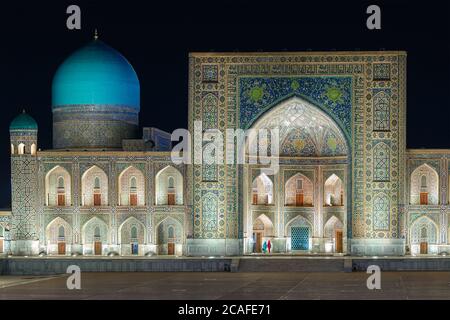 Tilya Kori Madrasa et mosquée avec dôme bleu et pishtaq ornementé la nuit. Madrasah Tilya Kari avec iwan et coupole cyan à Samarkand, Ouzbékistan. Banque D'Images