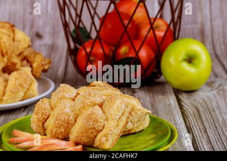 Strudel à la cannelle de pomme avec pommes fraîches rouges et vertes dans un panier sur une table en bois. Banque D'Images