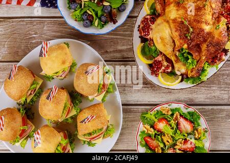 Poulet, sandwichs et salade sur une table en bois avec drapeaux américains. Banque D'Images
