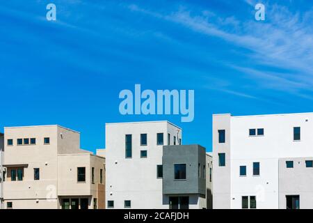 Vue extérieure d'un nouveau bâtiment résidentiel de faible hauteur multifamilial typique sous un beau ciel bleu Banque D'Images