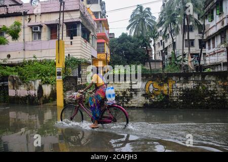 Kolkata, Inde. 06e août 2020. Une femme qui traverse une rue inondée après les pluies.plusieurs zones sont inondées en raison de la pluie nocturne de Kolkata qui affecte la vie quotidienne des gens très mal, en particulier pour se déplacer dans la ville. Crédit : SOPA Images Limited/Alamy Live News Banque D'Images