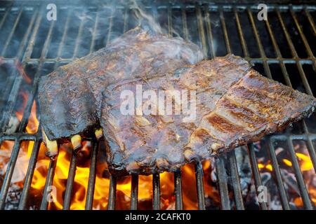 Côtes de bœuf de rechange sur barbecue avec flamme et charbon de bois Banque D'Images