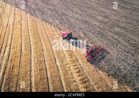 Tracteur travaillant dans les champs, vue aérienne, foin dans le champ. La vue du dessus. Le tracteur récolte de l'herbe sèche. Banque D'Images