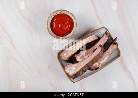 Côtelettes de porc grillées sur l'assiette avec sauce épicée Banque D'Images