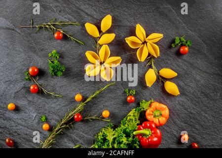 Pâtes de blé dur jumbo avec tomates cerises et paper sur fond noir. Banque D'Images