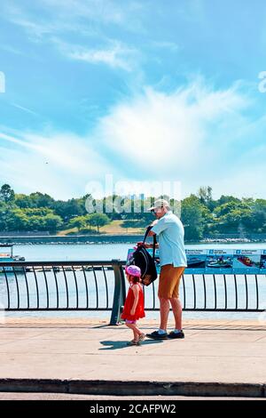 Père canadien et petite fille mignonne marchant près de la rivière dans le vieux port de Montréal, Québec, Canada. Banque D'Images