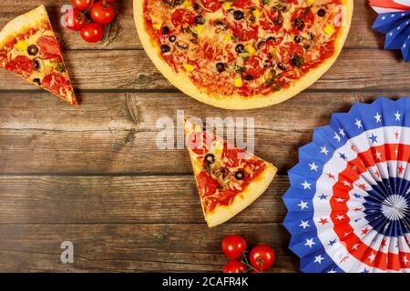 Faites la fête pour des vacances américaines avec une pizza suprême sur une table en bois rustique. Banque D'Images