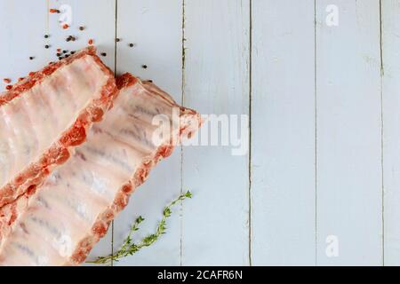 Côtes de porc de porc au filet crues avec herbes sur fond blanc. Banque D'Images