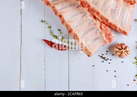 Côtelettes de bœuf au filet crues avec herbes sur fond blanc. Banque D'Images