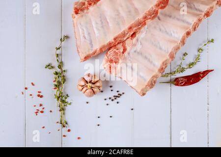 Côtelettes d'agneau de filet crues avec herbes sur fond blanc. Banque D'Images