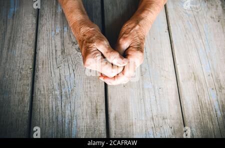 Femme âgée mains sur fond rustique en bois. Femme âgée avec les doigts croisés. Paumes froissées vers l'avant. Religion, prenez soin, jour des mères Banque D'Images