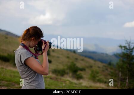 la photographe de fille prend de hautes photos dans les montagnes Banque D'Images