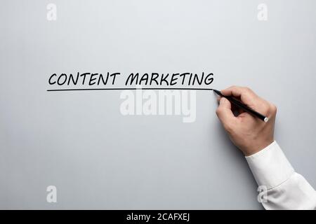 Homme d'affaires main écrivant les mots contenu marketing sur fond gris. Concept de formation marketing de contenu. Banque D'Images
