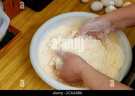 Femme mélangeant de la farine et du fromage pour faire de la pâte à pain au fromage. Cuisine du Paraguay. Banque D'Images