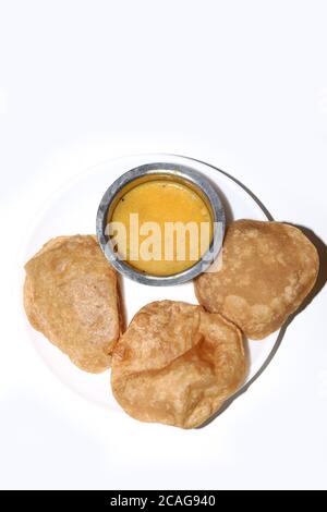 Poori Saagu - délicieux poori frits (puri) servi avec curry de pommes de terre épicé sur fond blanc Banque D'Images