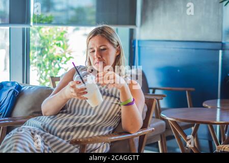 Une femme imsatisfaite et grognante avec une mauvaise attitude, une femme émotive en colère contre la qualité du service dans un café-restaurant, n'aime pas la boisson. Insatisfait émotionnel douteux Banque D'Images
