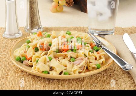 Cocotte de nouilles de thon sur une assiette avec des pois et des carottes Banque D'Images