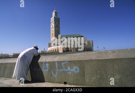 24.12.2010, Casablanca, , Marocco - UN homme est debout sur la banque en face de la mosquée Hassan II, la deuxième plus grande mosquée en Afrique. 0SL101107D004 Banque D'Images