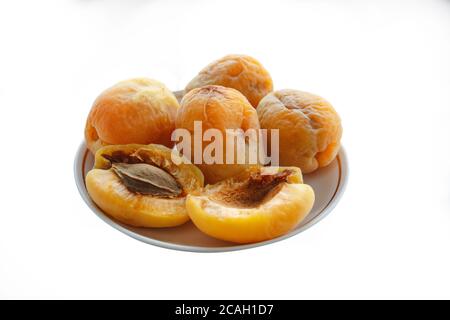 Groupe de vieux abricots aux abricots dans une plaque en céramique isolée sur fond blanc. Banque D'Images