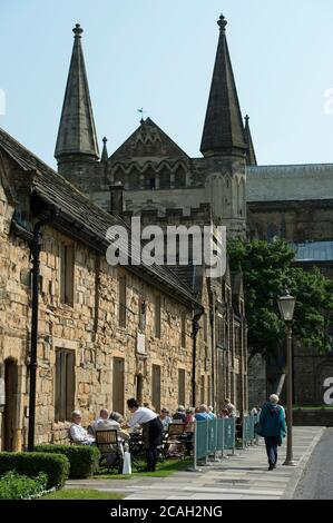 Les visiteurs dînant en plein air au Durham University café on the Green dans les maisons historiques d'Almshouses, à l'extérieur de la cathédrale. Banque D'Images