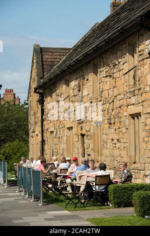 Les visiteurs dînant en plein air au Durham University café on the Green dans des almshres historiques à l'extérieur de la cathédrale. Banque D'Images