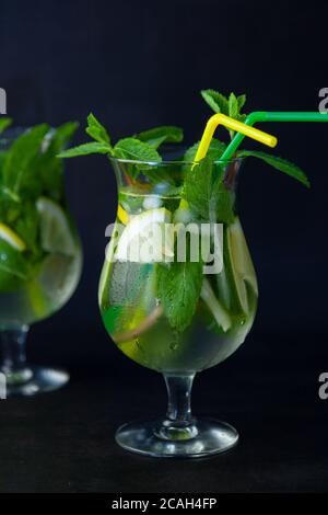 Cocktail mojito rafraîchissant à la menthe d'été avec rhum et glace sur fond noir. Cocktail Mojito sur une table en pierre sombre. Verre haut vitreux pour Banque D'Images