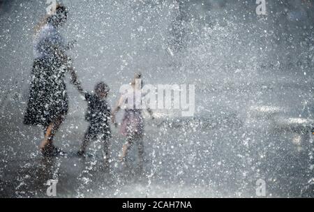 Munich, Allemagne. 07e août 2020. Une femme et deux enfants se refroidissent au Stachus dans un puits. Credit: Sven Hoppe/dpa/Alay Live News Banque D'Images